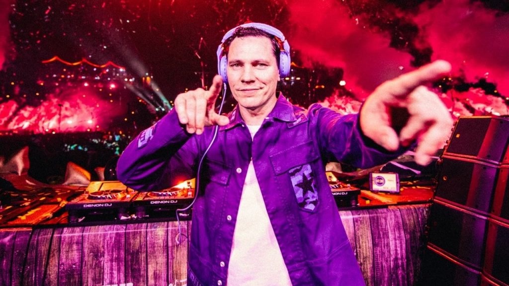 Tiësto performing and pointing to a camera at a concert