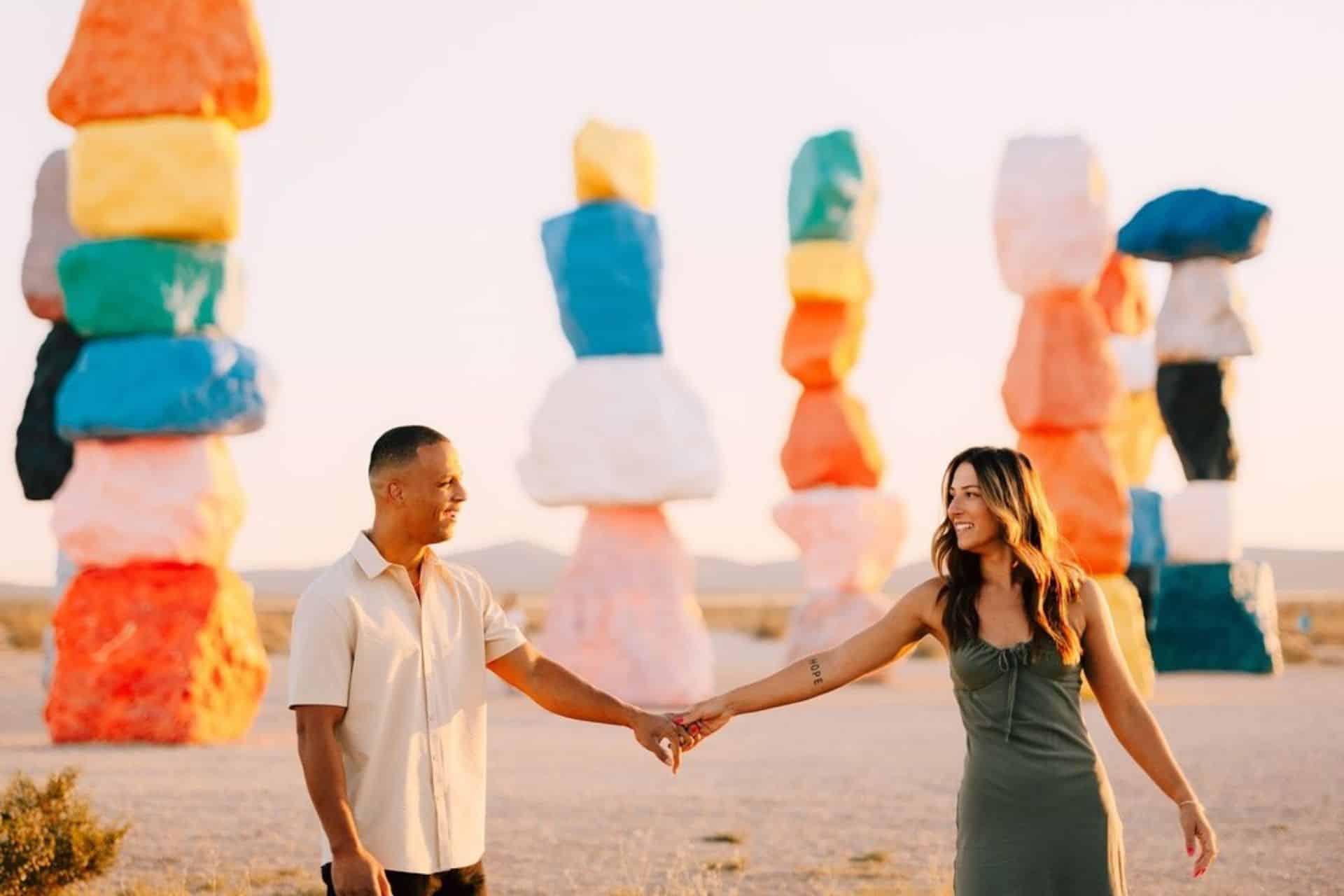 Couple posing in front of Seven Magic Mountains