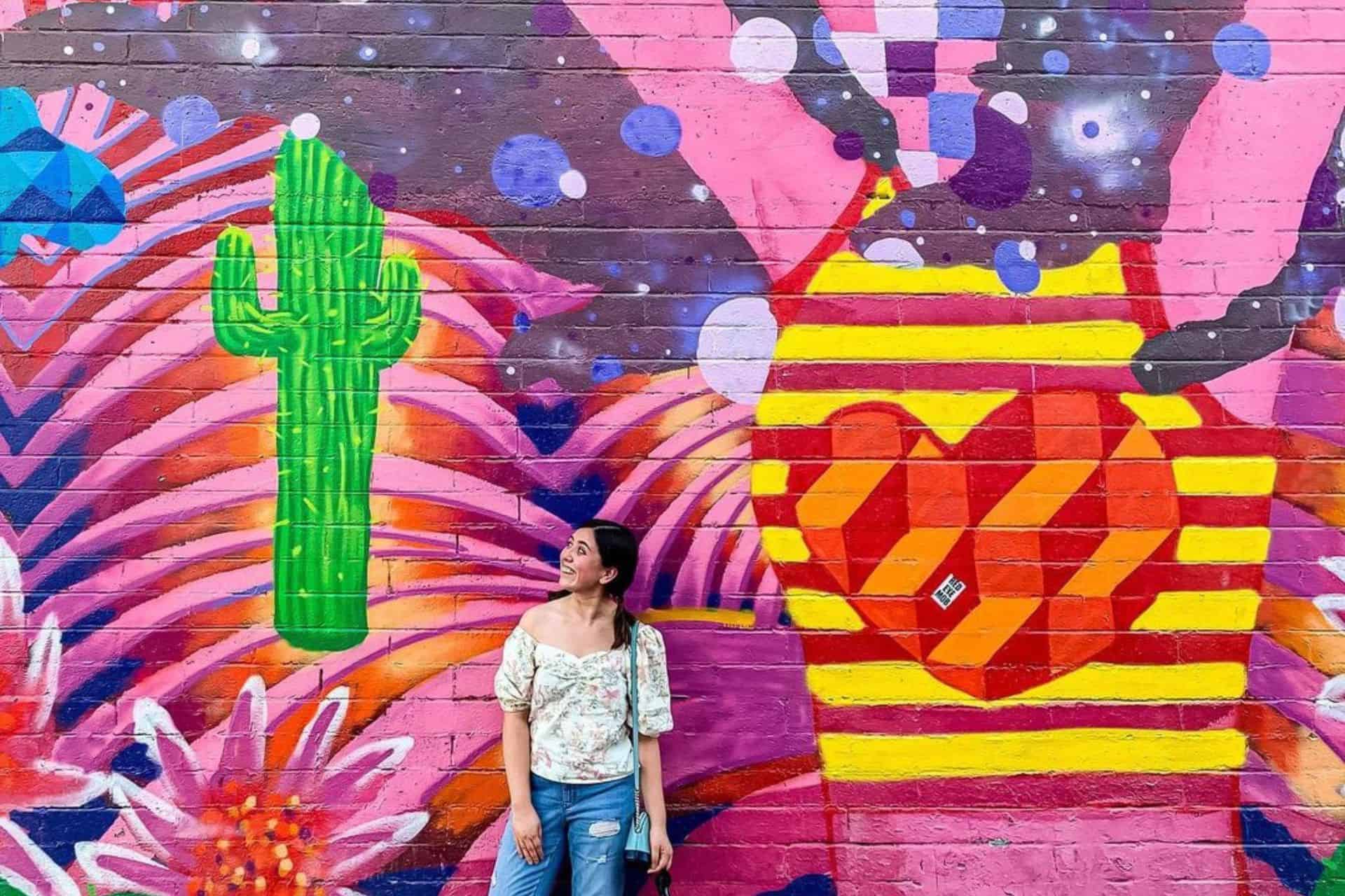 Woman posing in front of a Vegas mural at the Arts District