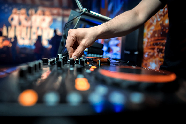 A DJ using a mixer at a night club 