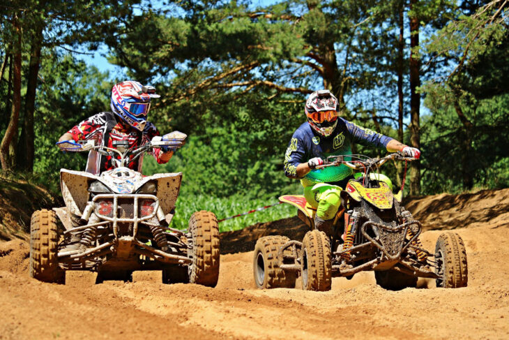 Two people riding ATVs