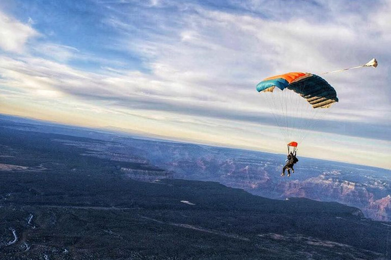  Two people skydiving into the Grand Canyon