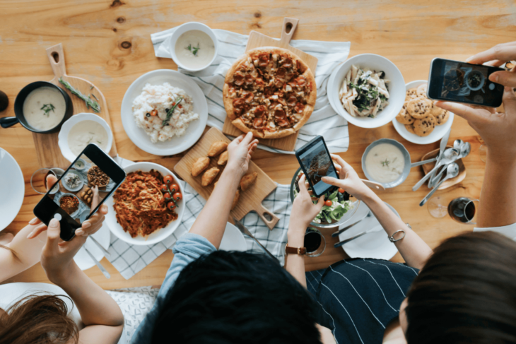 A group of friends take pictures of their buffet spread