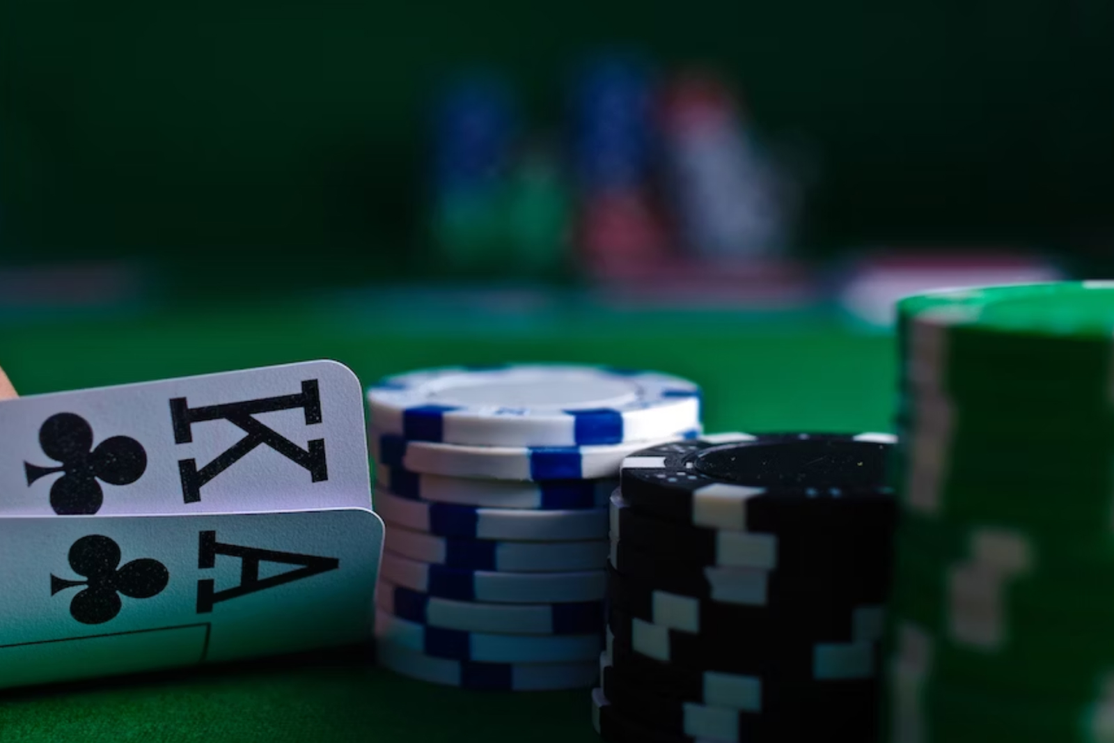 Playing cards and poker chips on a green table 
