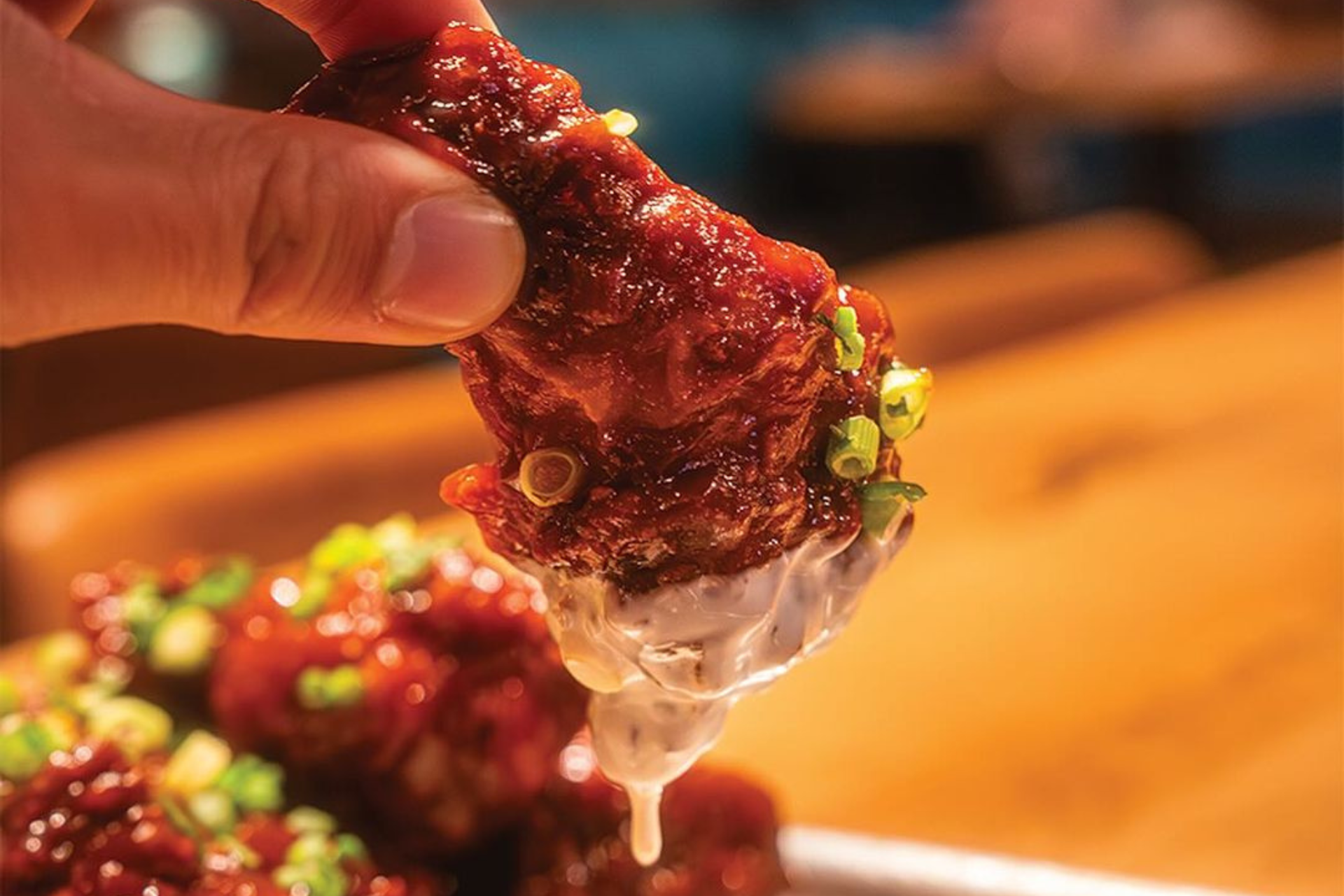 Korean-style chicken wings from BrewDog Las Vegas, NV dipped in sauce